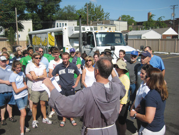El Padre Robert Lombardo dirige a los voluntarios que están listos para ayudar con la Mobile Food Pantry (Despensa Móvil de Alimentos), que atiende alrededor de 250 familias en el West Side de Chicago una vez al mes.